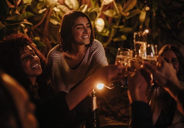 happy-young-adult-friends-celebrating-with-drinks-at-bar-together-in-the-evening.jpg